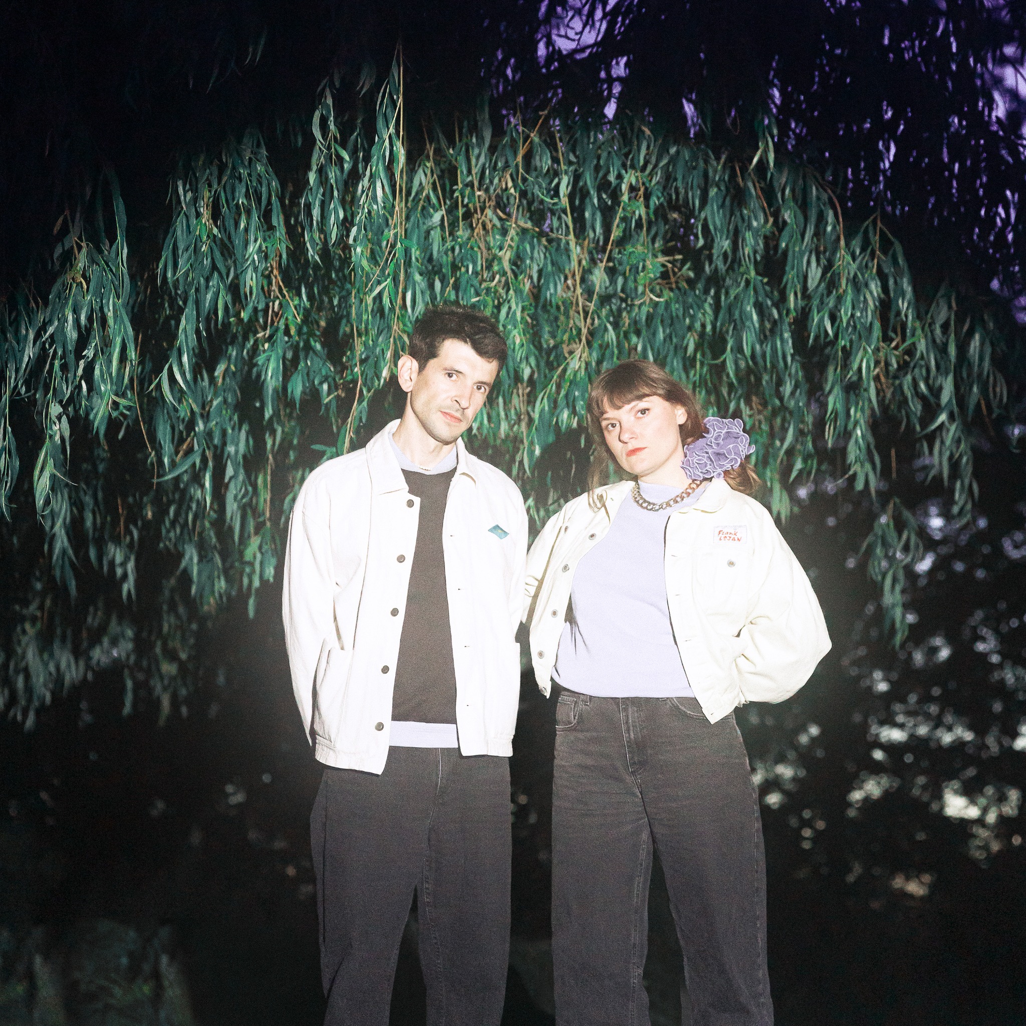 Anna Bozovic and Théo Noël-Apperry, oda., beneath the foliage of a tree